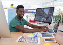 Portrait of smiling executive working on laptop in office